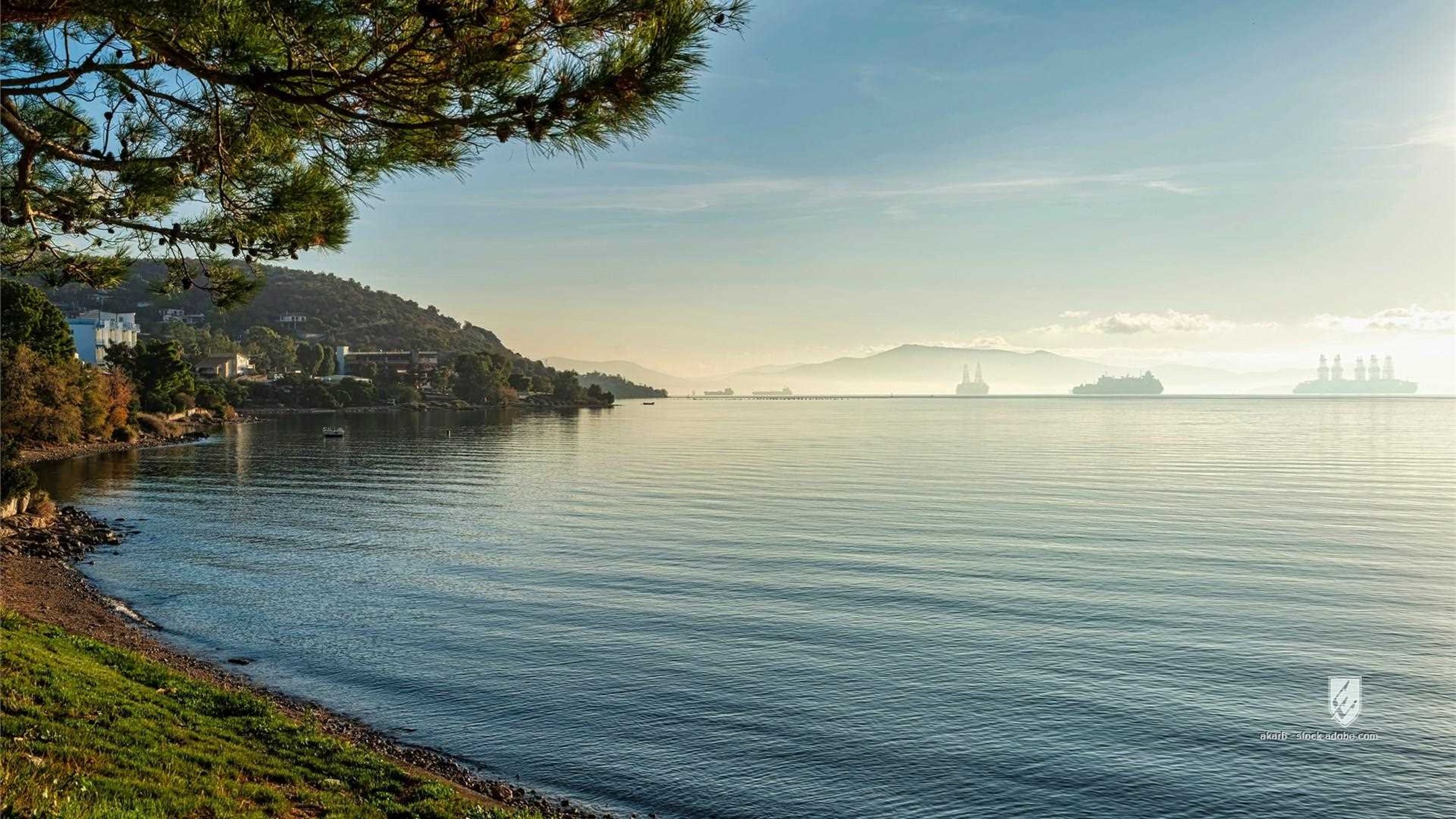 Elefsina Greece bay sea ocean water mist fog haze morning sunrise sunlight reflection ships silhouettes distant tranquil